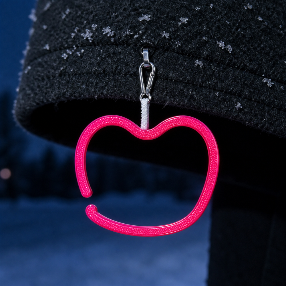 Pinkki hymynmuotoinen heijastin tummassa talvitakissa