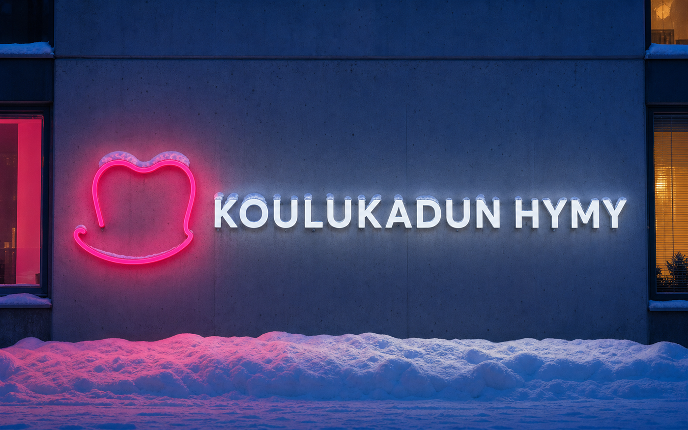 Koulukadun Hymyn valaistu kyltti lumisella julkisivulla